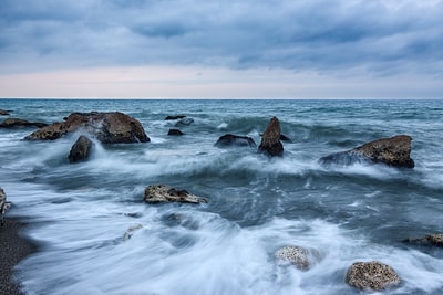 一个舞动的海浪与岩石的照片